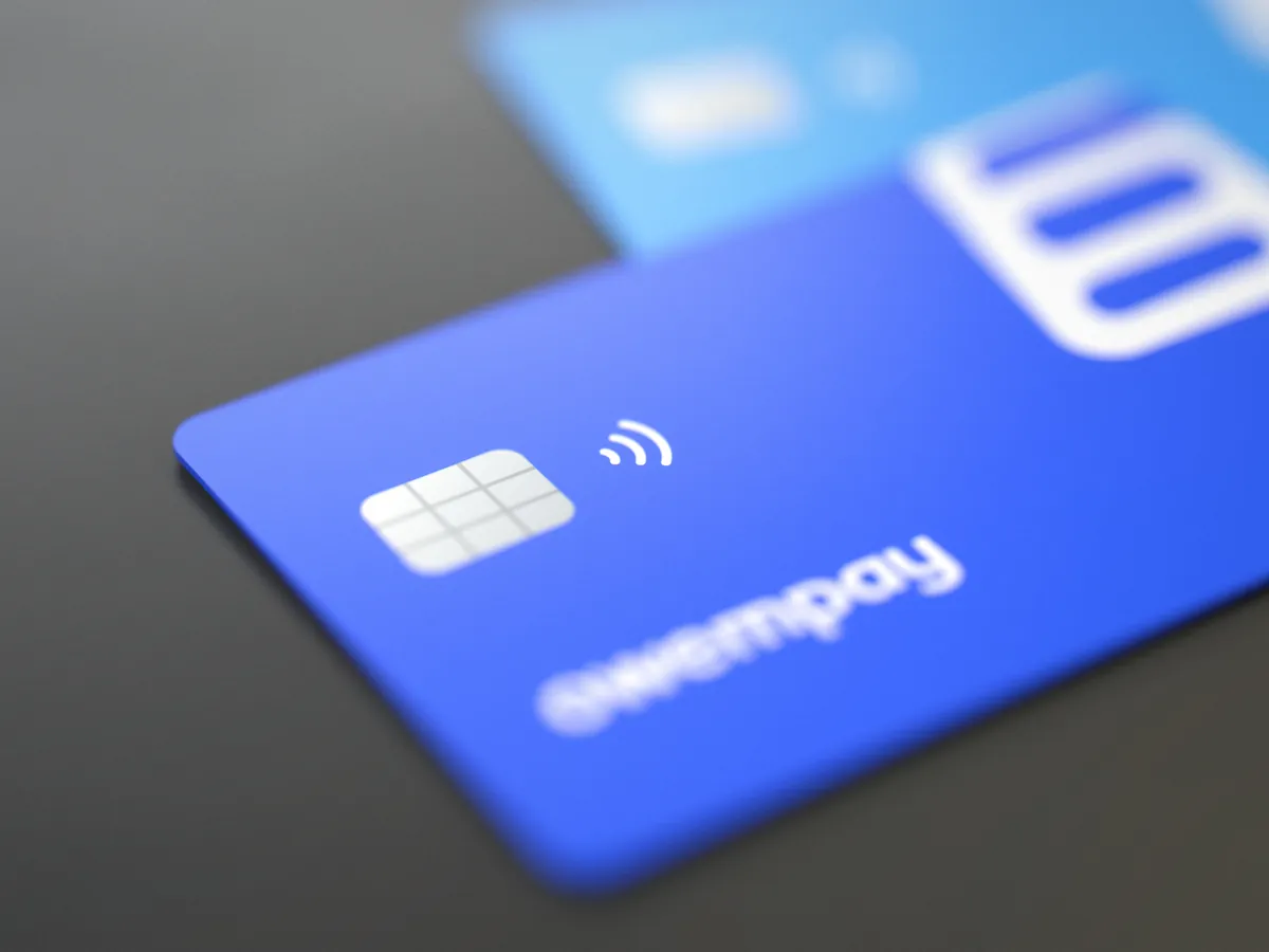 Close nos dois cartões sobrepostos: o chip, o contactless e a palavra owempay em foco no cartão azul; o cartão azul claro com o símbolo branco atrás
