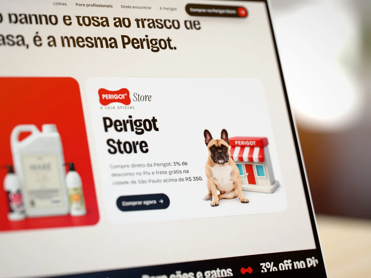 Close na tela de um notebook: a porta da Perigot Store em foco, com a assinatura Perigot Store, o texto da loja oficial e o botão Comprar agora; a porta vermelha da Perigot desfocada ao lado